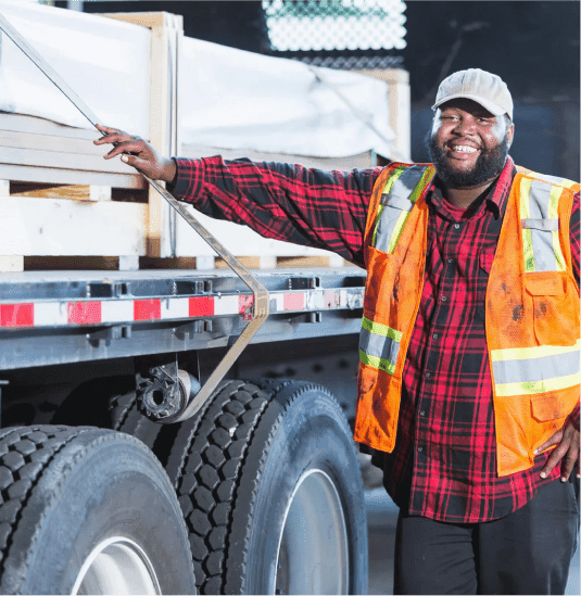 Carrier in a safety vest standing next to a semi-truck